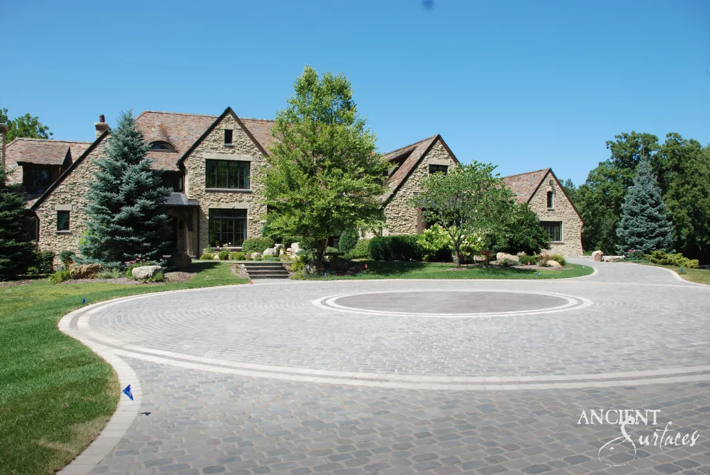 Circular antique reclaimed limestone cobblestone driveway laid in a fanned pattern in front of a stone country house
